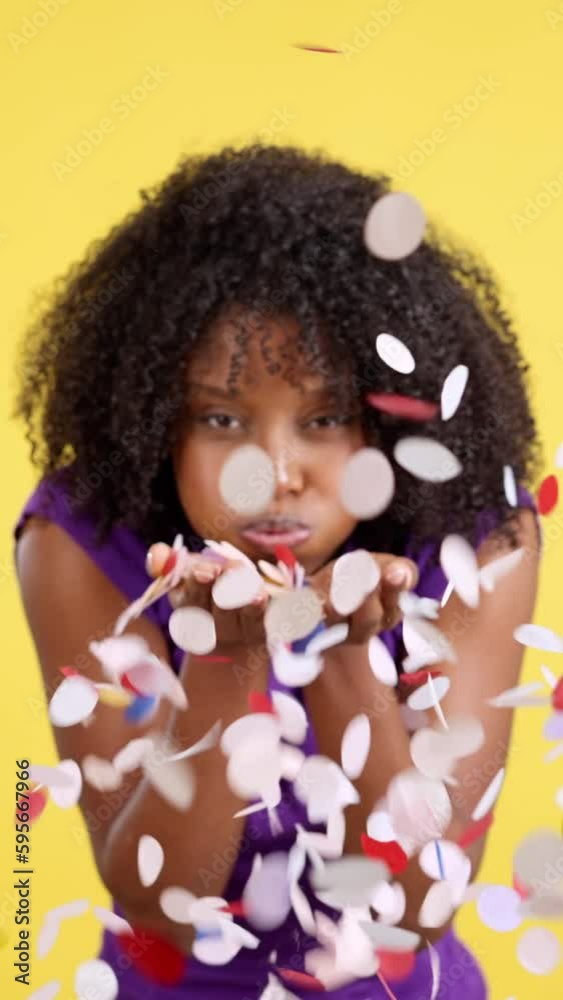 Cheerful Afro woman blowing confetti while celebrate Cheerful Afro woman blowing confetti while celebrate