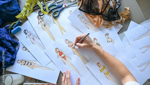 Fotografie Faceless woman draws sketches of swimwear with a pencil