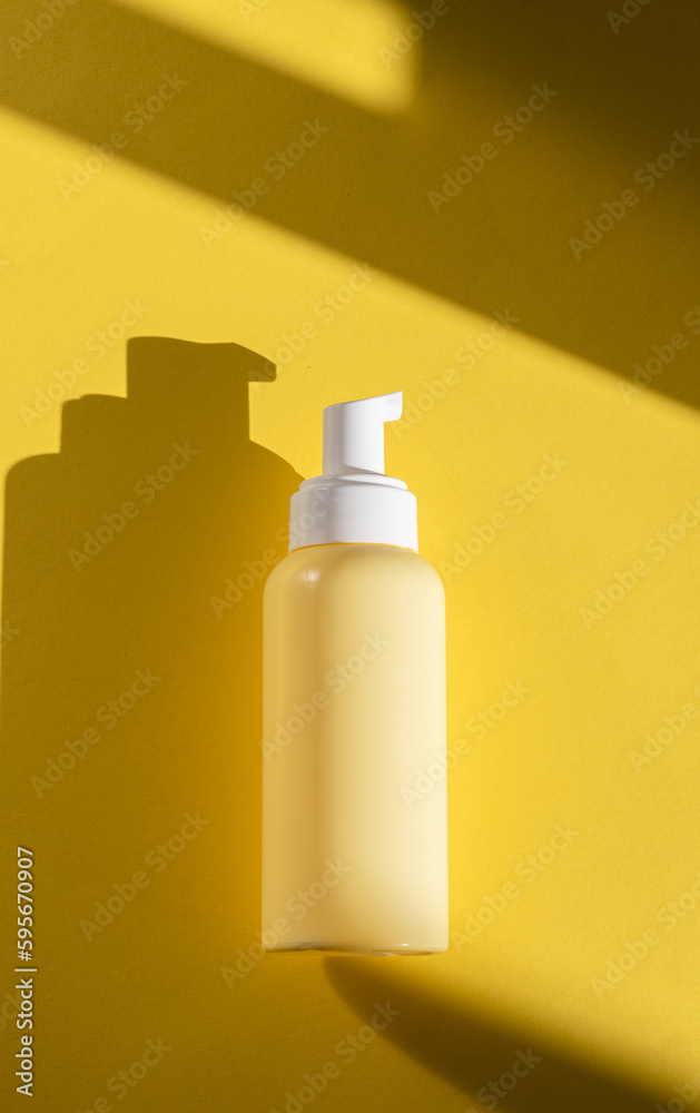 Yellow bottle with a dispenser on a yellow background. Yellow bottle with a dispenser on a yellow background.