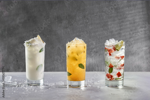 set of cocktails prepared with narutal fruit, lemon, strawberry, coconut, passion fruit on a gray background photo