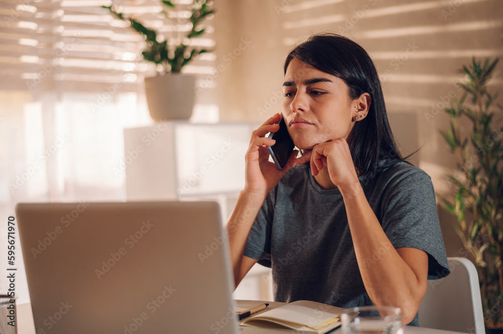 Focused businesswoman resolving work related problems while talking on the phone