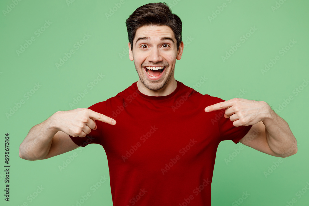 Young happy fun brunet caucasian man he wears red t-shirt casual clothes point index fingers on himself look camera isolated on plain pastel light green background studio portrait. Lifestyle concept. Young happy fun brunet caucasian man he wears red t-shirt casual clothes point index fingers on himself look camera isolated on plain pastel light green background studio portrait. Lifestyle concept.