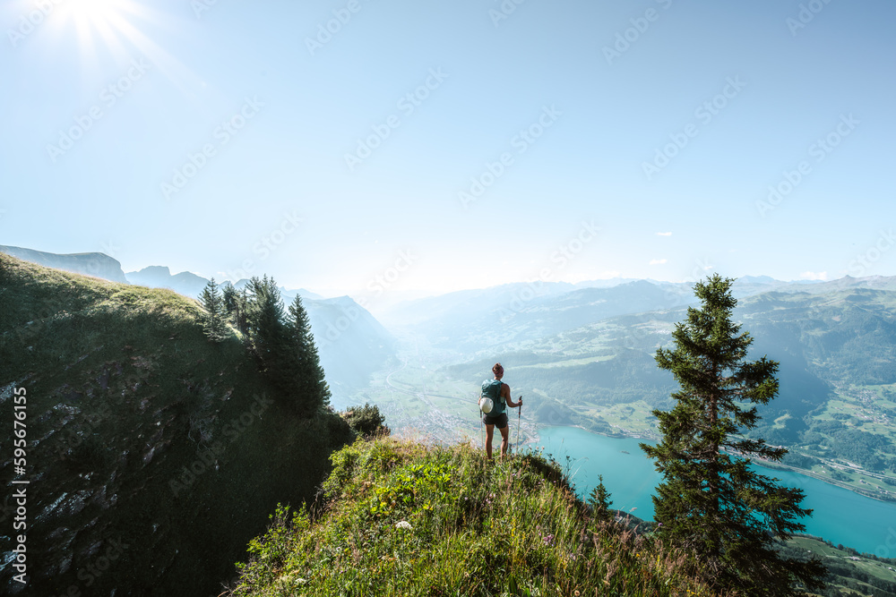 Sporty woman enjoys the view from a vantage point on the Walensee in the morning. Schnürliweg, Walensee, St. Gallen, Switzerland, Europe.