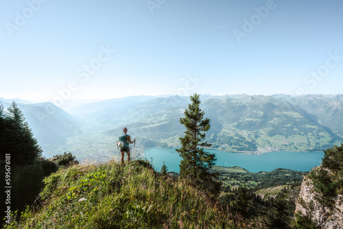 Sporty woman enjoys the view from a view point on the Walensee in the morning. Schnürliweg, Walensee, St. Gallen, Switzerland, Europe.