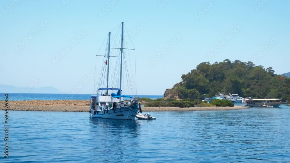 Motor yachts sailing by green beach line. A motor modern yacht stoped by the tropical green beach line in summer. A concept of sea relaxation with modern boats. Motor yachts sailing by green beach line. A motor modern yacht stoped by the tropical green beach line in summer. A concept of sea relaxation with modern boats.