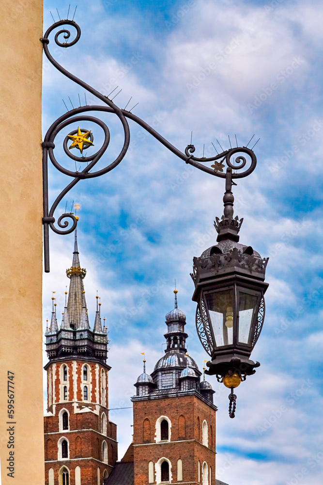 vintage retro lantern and beautiful medieval towers of St Mary's Basilica in day light, Krakow, Poland