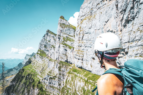 Shoulder view of woman enjoying scenic view on Churfürsten mountain range in the background. Schnürliweg, Walensee, St. Gallen, Switzerland, Europe. photo