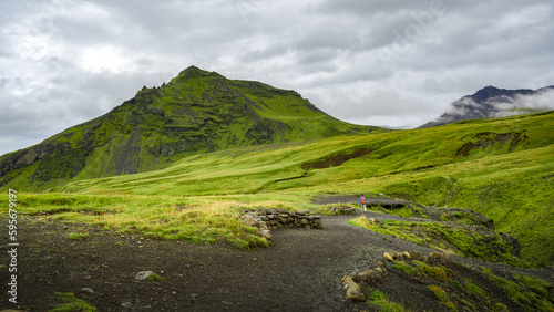 Fototapeta Naklejka Na Ścianę i Meble -  Lone hiker walking the trails, lush moss and meadows in Skogafoss area, Iceland