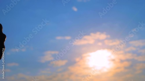 Man and woman hands silhouettes are bumping fists against the sunset or sunrise sky - sun lens flares, close up view. Approval, informal greeting, agreement, giving dap and teamwork concept photo