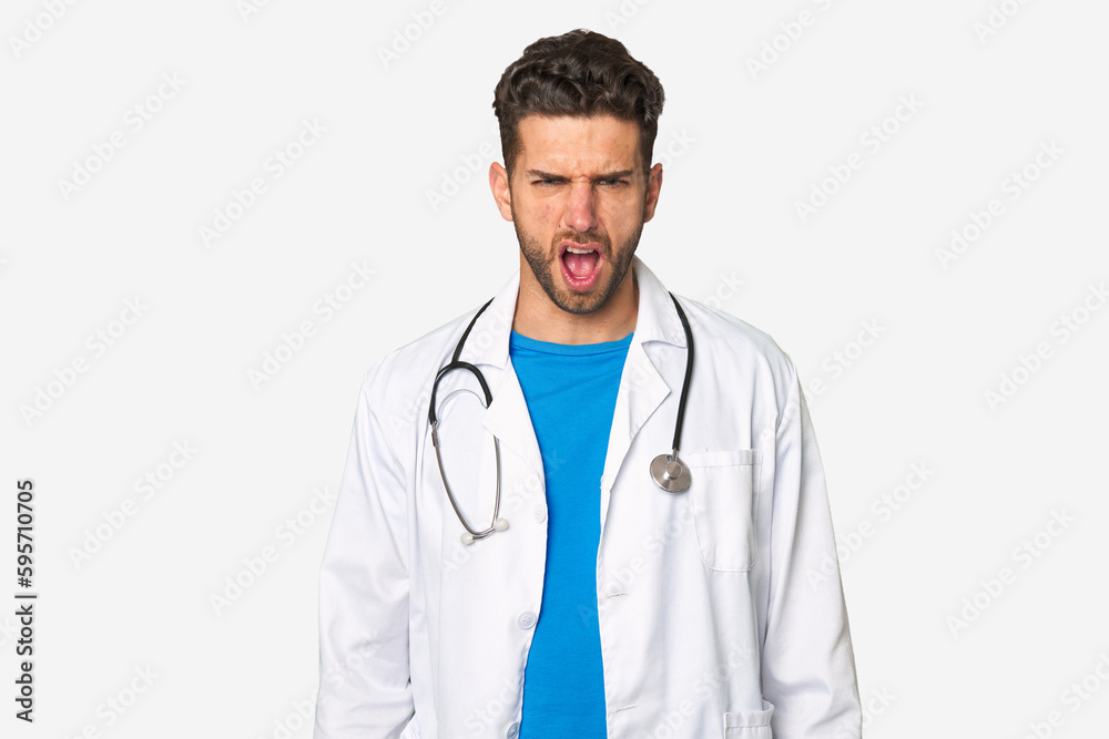 Young doctor man screaming very angry and aggressive.