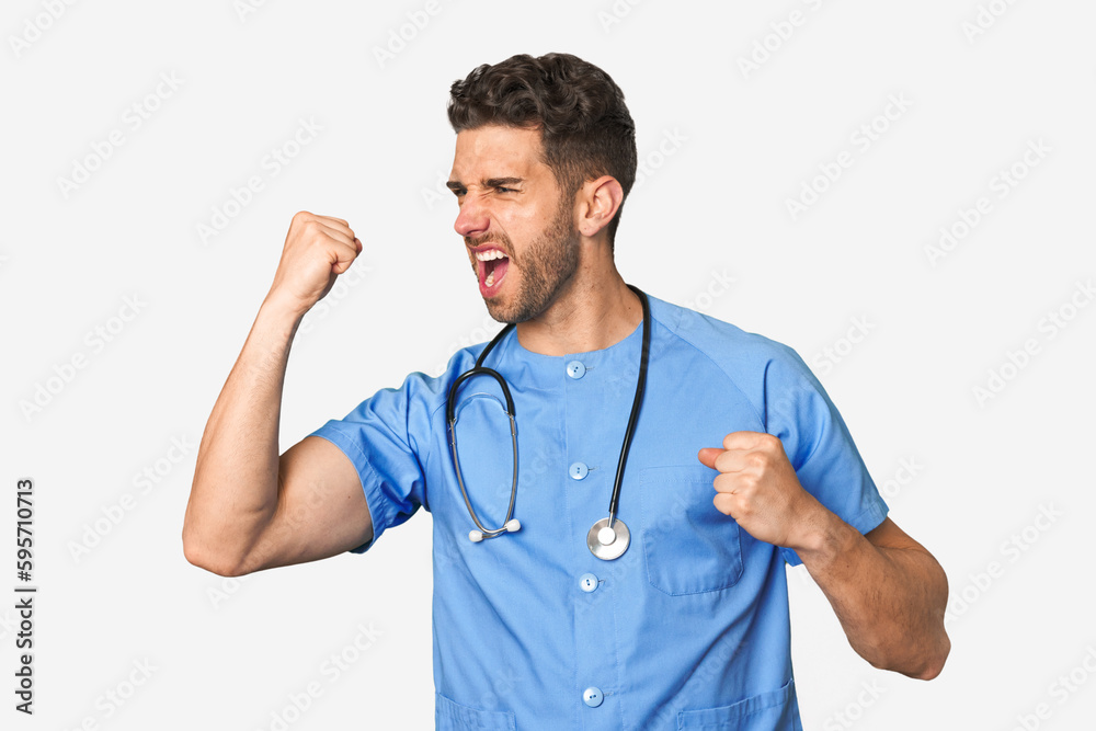 Young nurse man raising fist after a victory, winner concept. Young nurse man raising fist after a victory, winner concept.