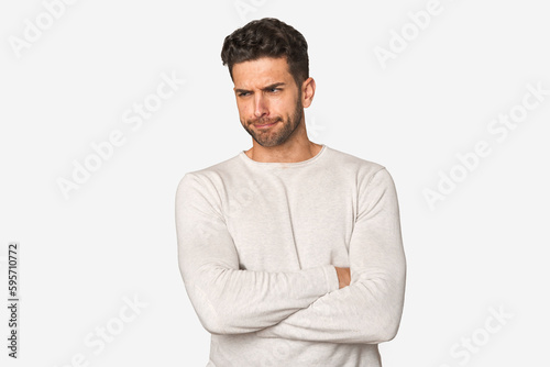 Young handsome man isolated frowning face in displeasure, keeps arms folded.