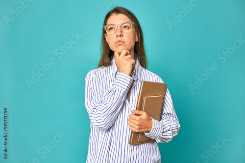 A young caucasian secretary woman isolated looking sideways with doubtful and skeptical expression.