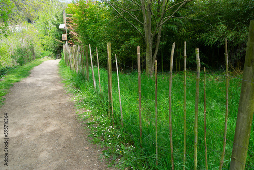 Dirt path with metal fence and wooden slats