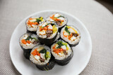Kimbap is a traditional Korean dish made of rice, vegetables, and meat or seafood rolled in seaweed. It represents the country's rich culinary heritage and cultural diversity