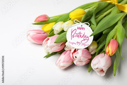 Beautiful bouquet of tulip flowers with Happy Birthday card on white background #595720336