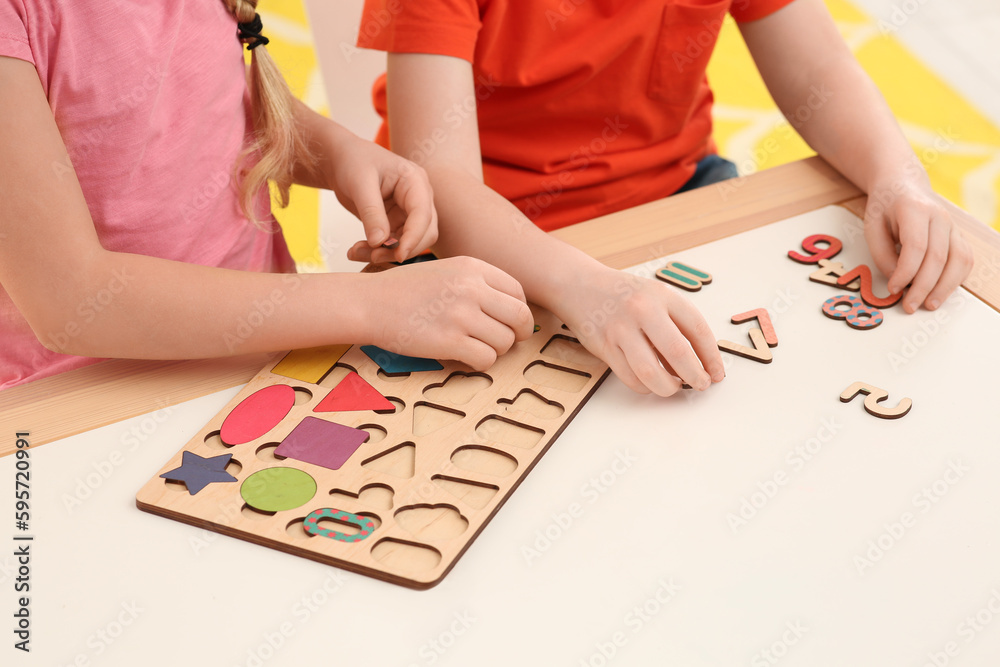 Fototapeta premium Children playing with math game kit at desk indoors, closeup. Learning mathematics with fun