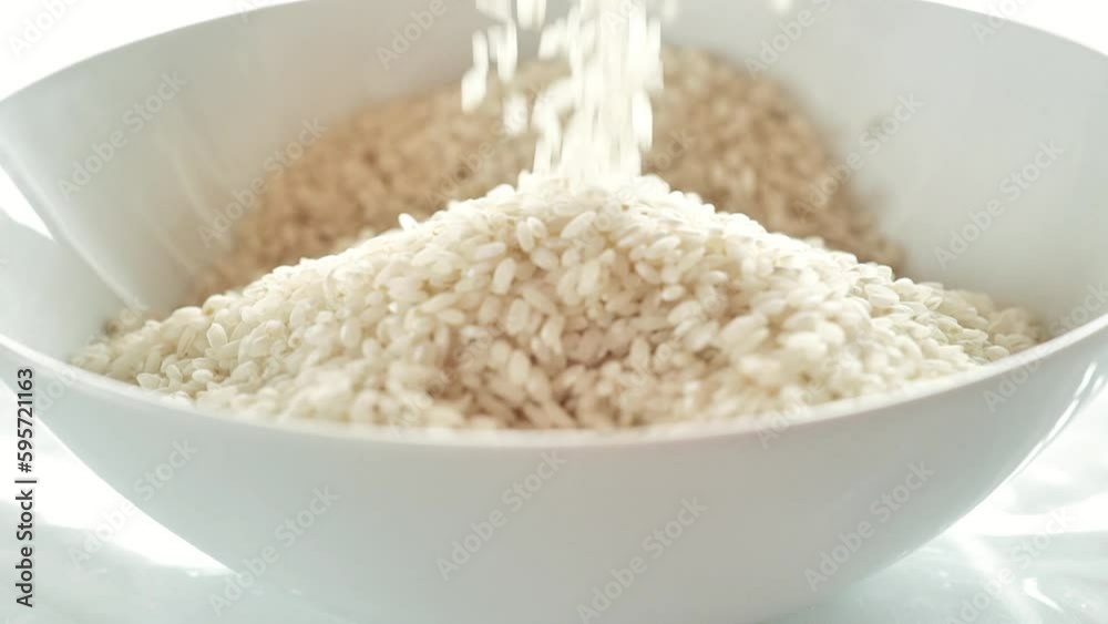 Hands pour rice into a bowl. rice plate. Round grain white polished rice .Long shelf life products. carbohydrate food. 4k footage