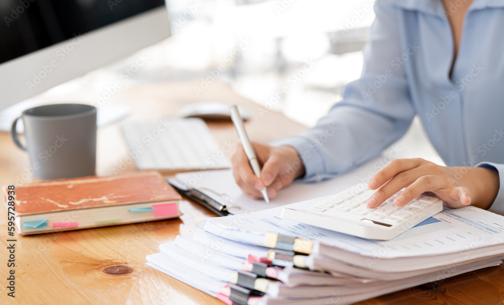 Businesswoman or accountant working Financial investment on calculator, calculate, analyze business and marketing growth on financial document data graph, Accounting, Economic, commercial concept. Businesswoman or accountant working Financial investment on calculator, calculate, analyze business and marketing growth on financial document data graph, Accounting, Economic, commercial concept.