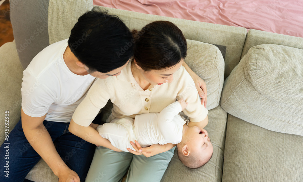 Smiling mother and father holding newborn son at home Smiling mother and father holding newborn son at home