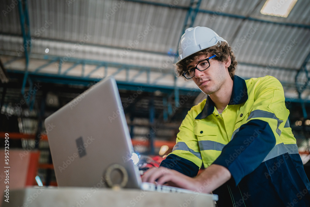 Professional engineer holding robot controller checking and repairing automatic robotic machine at industrial factory, Technician worker working with robotic arm system for manufacturing production