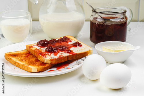 Useful breakfast.  Toaster and bread toast, milk, jam, cheese, butter. top view