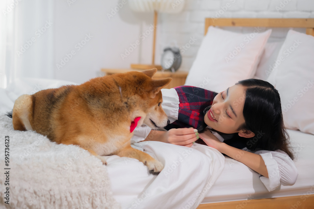 Beautiful asian woman lying on white bed in bedroom while looking at each other with smile on her face. Beautiful asian woman lying on white bed in bedroom while looking at each other with smile on her face.