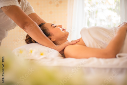 Masseuse used her skilled hands to knead and apply pressure to the muscles of the beautiful asian customer's shoulders.