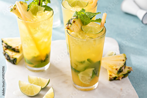 Pineapple mojito with limes and mint and a slice of pineapple