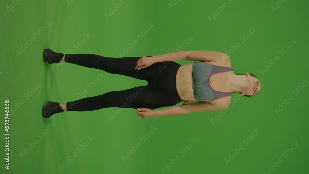 Vertical Video. Young Woman Doing Exercises for Stretching Arms and Shoulders on Green Screen. Chroma Key. Green Screen. Concept of Sport Healthy Active Lifestyle Vertical Video. Young Woman Doing Exercises for Stretching Arms and Shoulders on Green Screen. Chroma Key. Green Screen. Concept of Sport Healthy Active Lifestyle