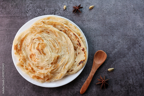 Kerala parathas porotta roti parotta barotta naan layered flatbread made from maida or whole wheat flour. Eat with spicy Asian chicken or beef or egg curry gravy. breakfast dish. Indian food.