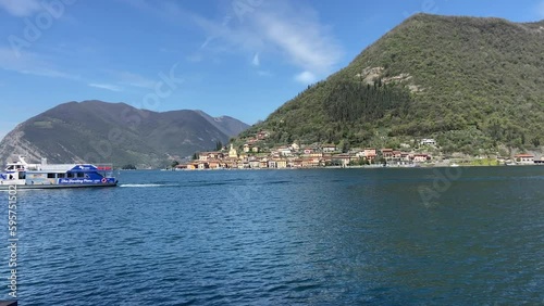 Tourist boat crossing Iseo lake from Isola mount at sunny day photo