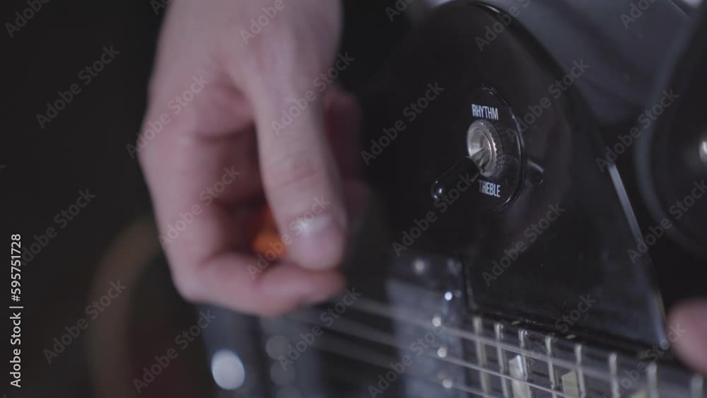 Close up of person playing electric guitar, flipping rhythm treble switch. Close up of person playing electric guitar, flipping rhythm treble switch.