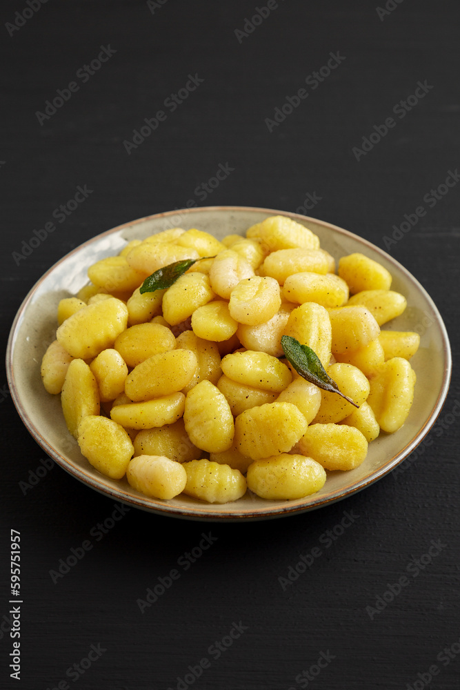 Homemade Easy Potato Gnocchi on a Plate on a black background, side view.