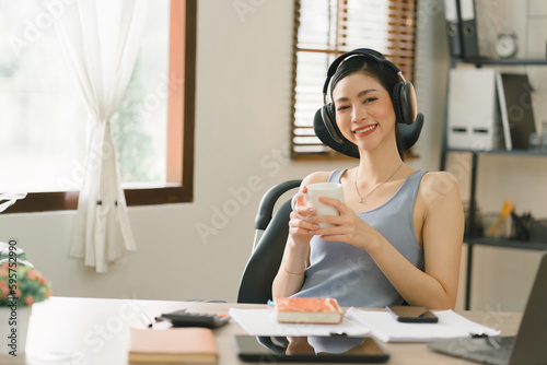 An image of a cheerful young businesswoman working in her home office represents the concept of remote work.