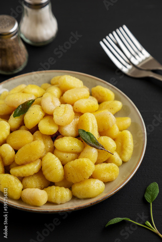 Fototapeta Naklejka Na Ścianę i Meble -  Homemade Easy Potato Gnocchi on a Plate on a black background, side view.