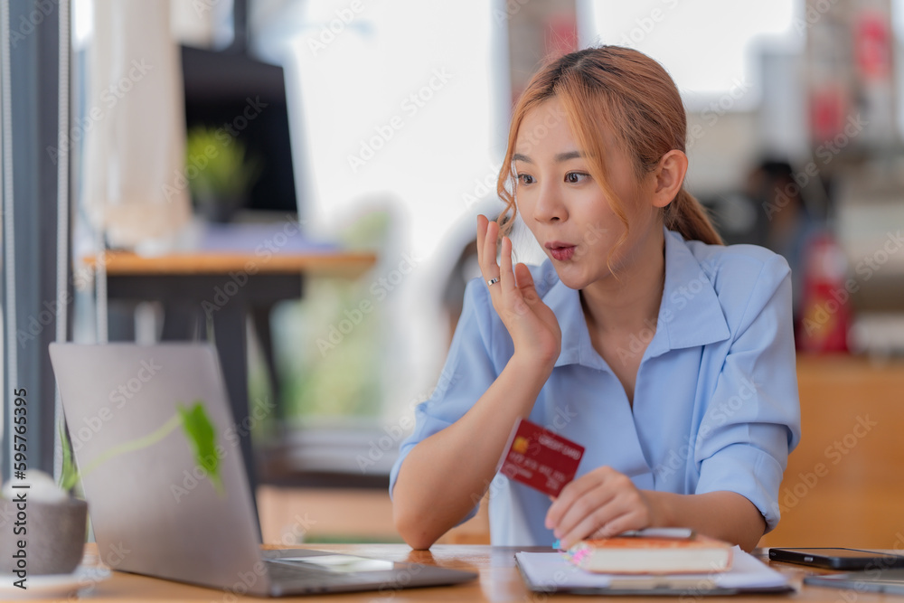 Asian woman using credit card shopping online at the office Asian woman using credit card shopping online at the office