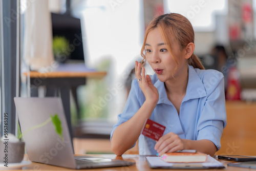 Asian woman using credit card shopping online at the office