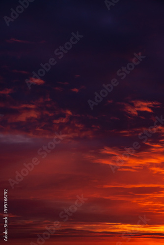 Cover page with deep blue sky with illuminated clouds at bloody sunset as a background.