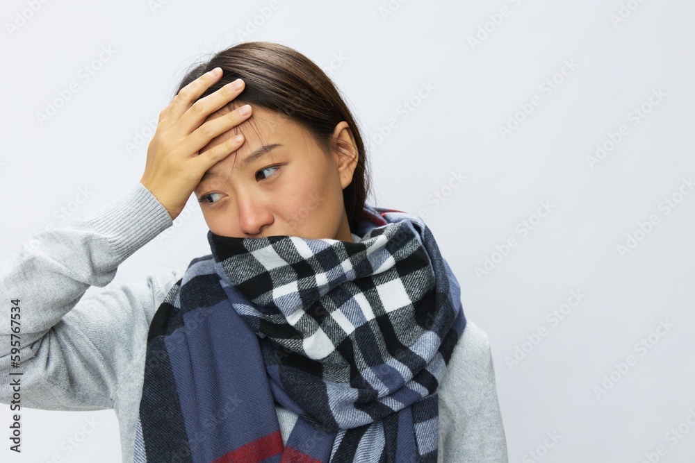 Asian woman cold flu raised hands from headache and toothache with fever sick from covid 19 virus in checkered scarf on white background, copy space Asian woman cold flu raised hands from headache and toothache with fever sick from covid 19 virus in checkered scarf on white background, copy space
