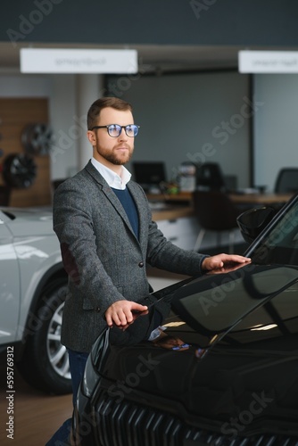 Man minded customer male buyer client in suit choose auto to go look aside want buy new automobile in car showroom vehicle salon dealership store motor show indoor Sales concept © Serhii