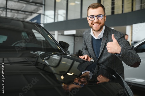 Portrait of happy customer buying new car. © Serhii