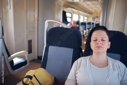 Woman sleeping in a train seat while travelling. photo