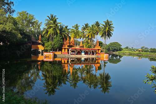 Temple on the lake. Hindu Temple. Palm trees and lake. Blue Sky. Lovely Water reflection. Maharashta. india