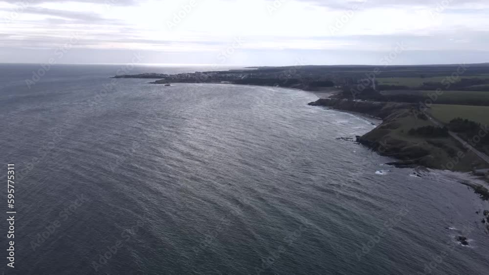 Slow Drone Panorama: Sea, Cliffs, Fields, Mountains, and Distant Settlement