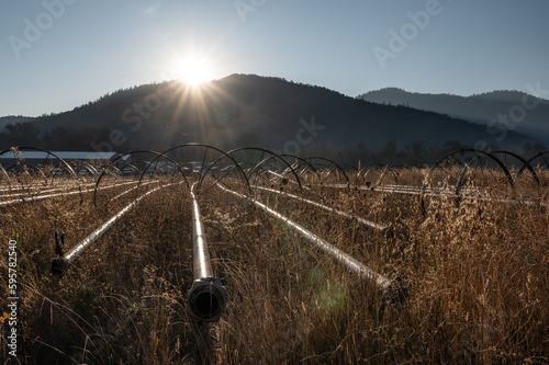 Wheelmove irrigation machine in a dry field at the base of the mountains at sunset