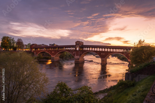 Nice view of Ponte Coperto (covered bridge) over Ticino river in Pavia at blue hour, Lombardy, italy.