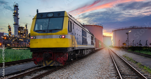 Oil transport train in industrial area, oil refining equipment, industrial refining pipeline closure, detail of oil pipeline with valves in large oil refinery at sunrise and oil tank area