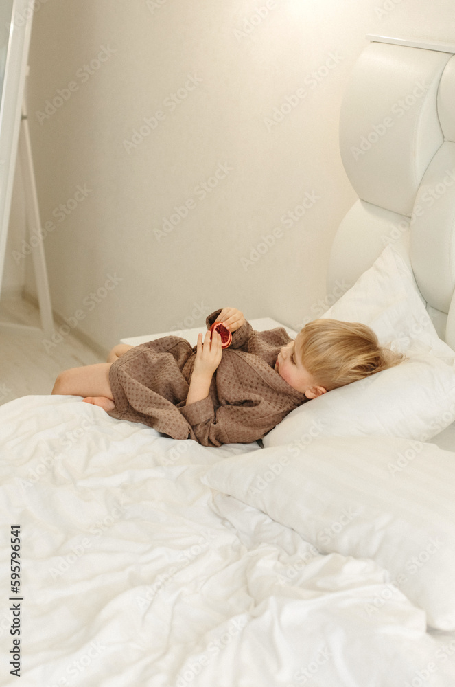 Portrait of a boy in a brown bathrobe, who is lying in bed, resting Portrait of a boy in a brown bathrobe, who is lying in bed, resting