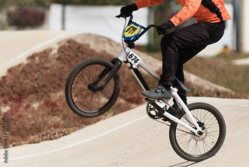 Young boy jumping with his BMX bike at pump track. BMX racing track. Cyclist riding on pump track. Rider in action at bike sport